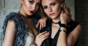 Two stylish models posing together indoors.